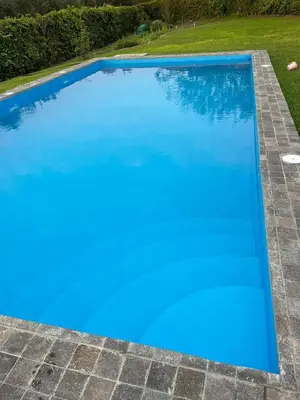 a large swimming pool with blue water in a yard at Casa de Campo Azpitia Perú in Santa Cruz de Flores