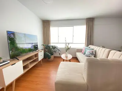 a living room with a couch and a flat screen tv at Mendiburu 2 Dormitorios by Casa Miraflores - Wifi - Hot Water in Lima
