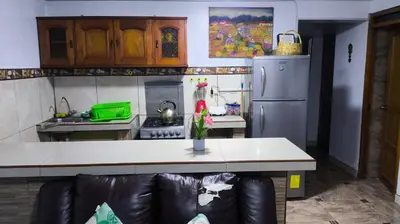 a kitchen with a couch in front of a counter at Victoria home san blas in Cusco