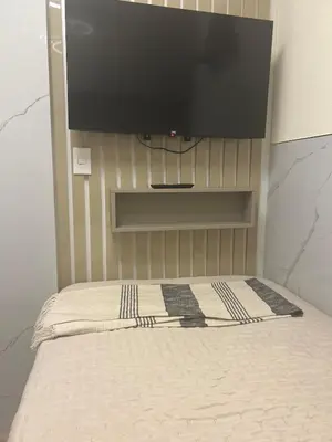 a bedroom with a bed with a flat screen tv on the wall at Luxury Ocean View Barranco Apt, 17th Floor AC in Lima