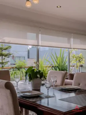a dining room table with chairs and a large window at Cozy Retreat in the Heart of Surco in Lima