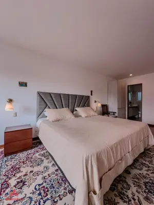 a large bedroom with a large bed and a rug at Cozy Retreat in the Heart of Surco in Lima
