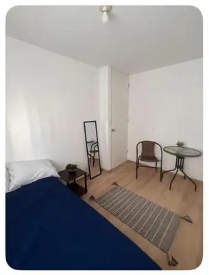 a bedroom with a bed and a table and chairs at Habitación con baño privado, duplex con ambientes compartidos in Lima