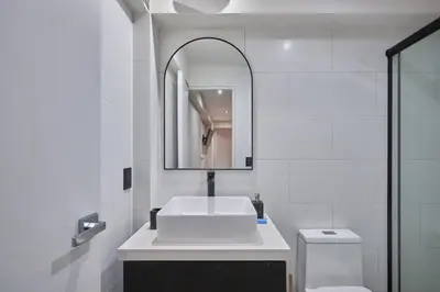 a white bathroom with a sink and a mirror at Geko | Contemporary 2BR w/Balcony near Costa Verde in Lima