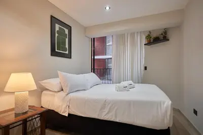 a bedroom with a bed with a lamp and a window at Geko | Contemporary 2BR w/Balcony near Costa Verde in Lima