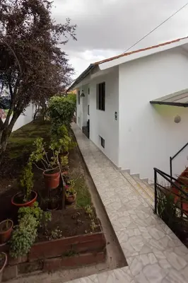 a white building with potted plants in a yard at San Blas Plaza Hotel in Cusco