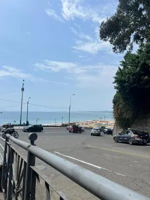 a parking lot with cars parked on a road next to the ocean at Departamento cerca al mar con terraza panoramica in Lima