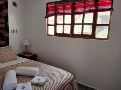 a bedroom with a bed and a window at Wasi Wasi in Urubamba