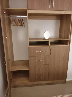 a closet with wooden cabinets and a mirror in it at Wasi Wasi in Urubamba