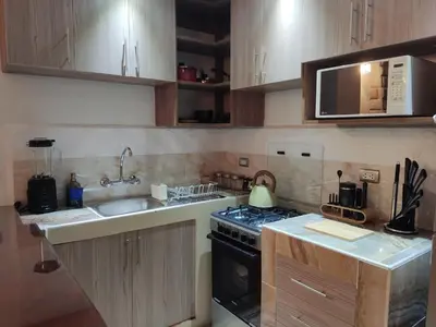 a small kitchen with a stove and a sink at Wasi Wasi in Urubamba