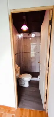 a small bathroom with a toilet and a light at La Viña de OsCar in Nuevo Imperial