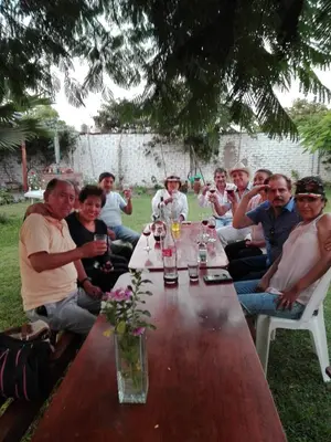 a group of people sitting around a wooden table at La Viña de OsCar in Nuevo Imperial