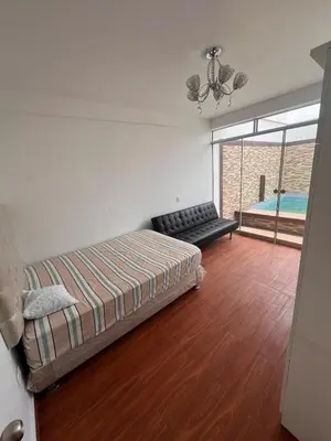 a bedroom with a bed and a couch and a pool at Casa de playa con Piscina I-101 in Punta Negra