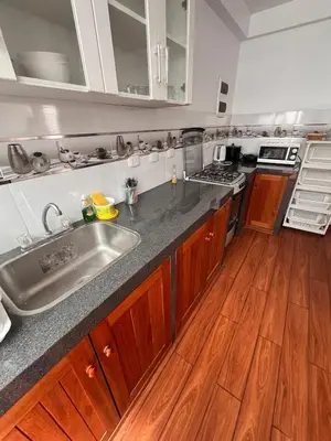 a kitchen with a sink and a wooden floor at Casa de playa con Piscina I-101 in Punta Negra