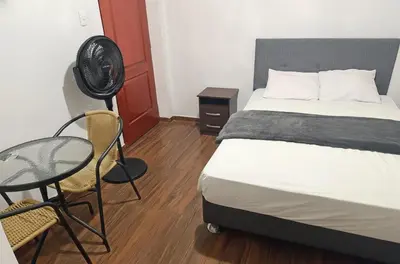 a bedroom with a bed and a table with a fan at Hospedaje Dajoka's in Lima