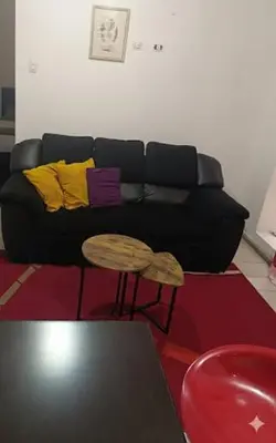 a living room with a black couch and a table at Hospedaje Dajoka's in Lima