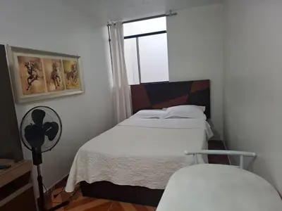 a small bedroom with two beds and a window at Lindo Atardecer in Ica