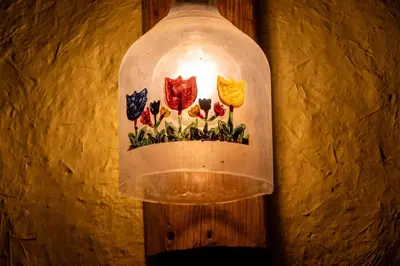 a light bulb with flowers painted on it hanging on a wall at Unu Samay Lodge in Urubamba