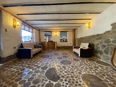 a living room with a stone floor and couches at Unu Samay Lodge in Urubamba