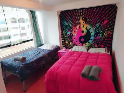 a bedroom with a pink bed and a large window at inti angelus house rooms in Cusco