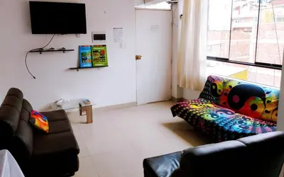 a living room with a couch and a flat screen tv at inti angelus house rooms in Cusco