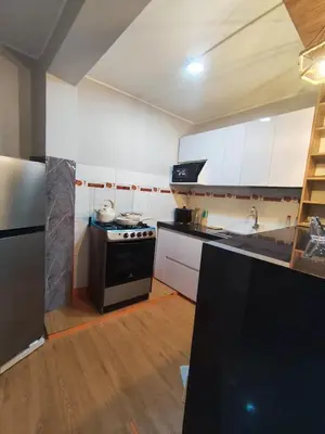 a kitchen with white cabinets and a black stove at Central and brand new apartment in Huamanga in Ayacucho
