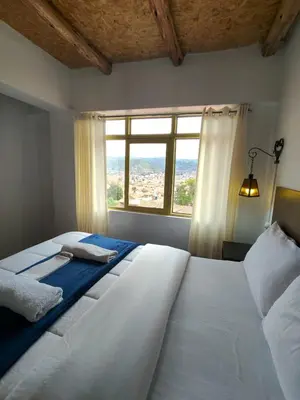 a bedroom with two white beds and a window at Imperial City Apartment in Cusco