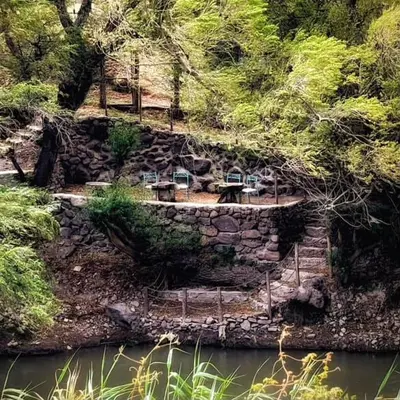a group of cars parked on a hill next to a river at Tiny Mountain River in Urubamba