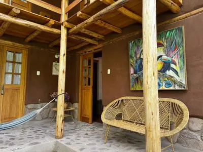 a house with a painting on the wall and a bench at Casa Nuestra in Urubamba