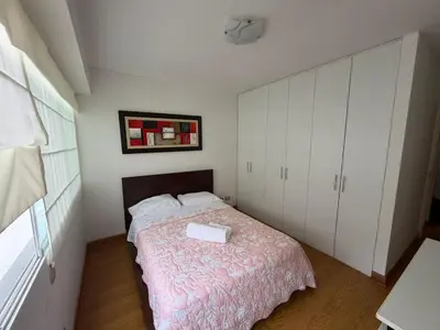 a bedroom with a bed and white cabinets at Duplex en miraflores av larco 1010 in Lima