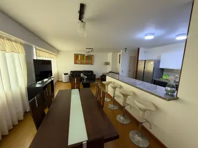 a kitchen and living room with a table and chairs at Duplex en miraflores av larco 1010 in Lima
