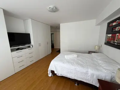 a bedroom with a bed and a flat screen tv at Duplex en Miraflores av larco 1010 in Lima