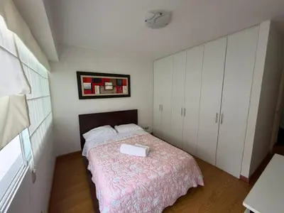 a bedroom with a bed and white cabinets at Duplex en Miraflores av larco 1010 in Lima