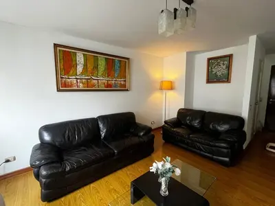 a living room with black leather couches and a table at Duplex en Miraflores av larco 1010 in Lima