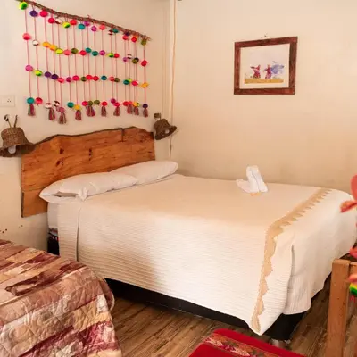 two beds in a room with christmas decorations on the wall at hospedaje Illary in Quinua