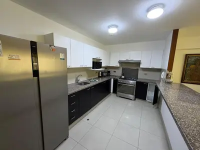 a kitchen with black and white cabinets and appliances at Apartamento con ascensor en segundo piso, Miraflores in Lima