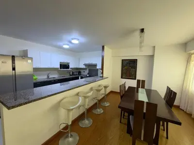 a kitchen with a table and chairs and a counter at Apartamento con ascensor en segundo piso, Miraflores in Lima
