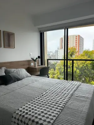 a bedroom with a large bed and a large window at Loft Bohemio a 1 cuadra de plaza Barranco in Lima