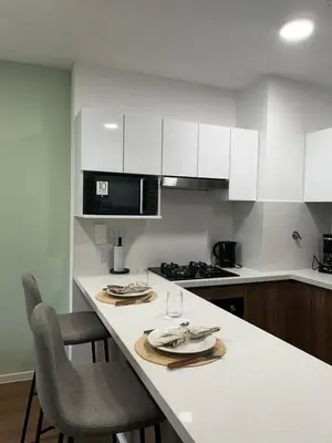 a kitchen with white cabinets and a white counter top at Loft Bohemio a 1 cuadra de plaza Barranco in Lima