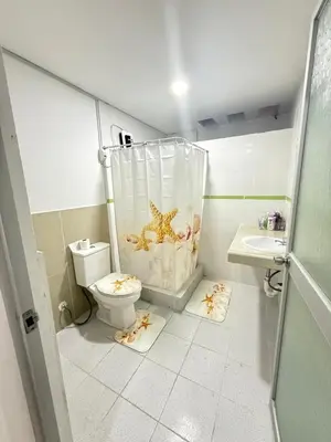 a bathroom with a toilet with a starfish shower curtain at Exclusivo departamento cerca al mar in Quebrada Seca