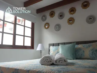 a bedroom with towels on a bed with a window at Casa Cayena in Lima