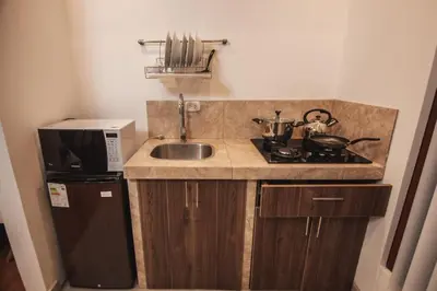 a small kitchen with a sink and a microwave at Florez de la Villa Apart Hotel in Cusco