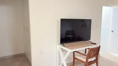 a room with a table with a television on a wall at Casa San José - Bungalow 5 in Ica