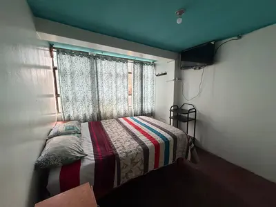 a small bedroom with a bed and a window at Hospedaje Tarapacá in Huancayo