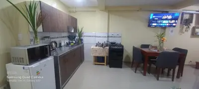 a kitchen with a counter and a table with a microwave at Inti Wasi Z in Cusco