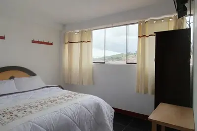 a bedroom with a bed and a window at Hospedaje Tikari in Chinchero