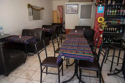 a restaurant with tables and chairs with a colorful table cloth at Hospedaje Tikari in Chinchero