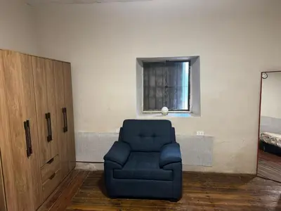 a blue chair sitting in a room with a window at Posada Bayoneta in Cusco