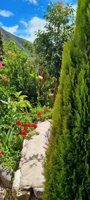 a garden with flowers and a stone path at Florez de la Villa Apartments in Urubamba