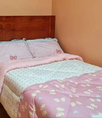 a bed with a purple comforter with bows on it at Cusco Apartment Prime Location in Cusco